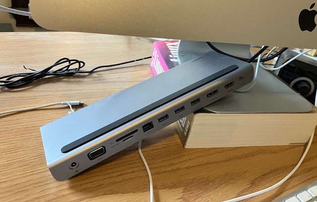 A USB hub dangling at an angle beneath an iMac screen