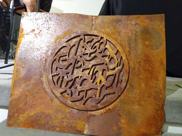 A rusty metal plate covered with D'ni symbols.