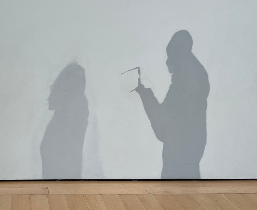 A wall painted to look like the shadows of two people walking past.