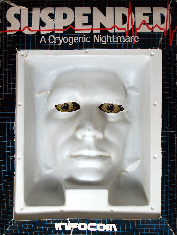 "Suspended: A Cryogenic Nightmare". A black game package with a white inset molded in the shape of an expressionless face. The eye-holes are cut out, and illustrated eyes are visible behind.